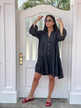 Vestido amplio de lino color verde lima, con cuello mao y abertura frontal con botones de coco. Presenta un diseño con canesú fruncido y volados en los puños de las mangas largas.