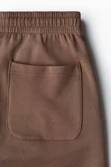 Short en felpa de algodón color marrón, con cintura elástica, bolsillos laterales y corte regular.