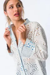 Camisa blanca con broderie y mangas largas con puños en color azul.