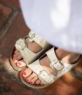 Sandalias de cuero con estampado animal print, dos hebillas ajustables y plantilla de cuero.