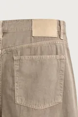 Jeans straight fit de corte recto confeccionados en denim de algodón con textura, color marrón, tiro medio, diseño de cinco bolsillos y cierre frontal con botón y cremallera.