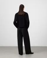 Sweater de punto color rosa, de corte corto con cuello redondo y mangas largas. Presenta acabados en canalé en cuello, puños y bajo. Confeccionado en una mezcla de lana merino y alpaca que ofrece una textura suave y abrigada.