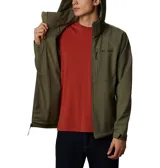 Chaqueta softshell Columbia modelo Cascade Ridge III, color verde oliva. Cuenta con capucha desmontable, cierre frontal completo, bolsillo con cremallera en el pecho, bolsillos laterales para las manos, puños ajustables y dobladillo regulable. Es resistente al agua y está confeccionada con un diseño libre de PFAS.