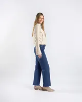 Campera estilo motero de símil cuero en color beige, con cuello alto, cierre frontal asimétrico y paneles acolchados en los hombros.