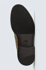 Zapato tipo derby con cordones, confeccionado en piel con acabado de serraje. Presenta horma redonda y suela a contraste.