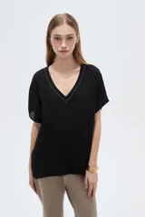 Blusa blanca de poliéster de corte holgado, con escote en V y mangas cortas.