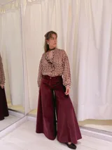 Pantalón de terciopelo color borgoña, de tiro medio y corte acampanado.