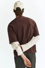 Remera H&M de algodón pesado, color marrón, con diseño boxy, cuello redondo ribeteado y mangas cortas con hombros caídos.
