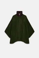 Capa de punto color verde oscuro con cuello subido de pana en color marrón. Presenta cierre frontal con cremallera metálica y diseño holgado.