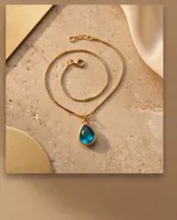 Collar de bronce con cadena fina eslabonada y dije en forma de gota con piedra color azul zafiro.