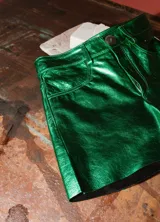 Shorts de cuero de tiro medio y corte recto, con acabado metalizado en color turquesa, bolsillos funcionales y cierre frontal con botón.