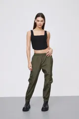 Babucha estilo cargo color verde oliva, confeccionada en tela técnica con acabado satinado. Presenta cintura elástica, bolsillos laterales con solapa y puños elásticos en los tobillos.