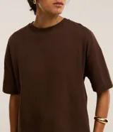 Blusa basica oversize de algodon color marron, con cuello redondo y mangas cortas con sisas desplazadas.