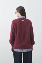 Cardigan de textura suave y efecto fluffy, color beige, con cuello redondo, cierre frontal con botones y puños acanalados.