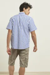 Camisa de manga corta con estampado de rayas verticales en azul y blanco, cuello abotonado y bolsillo frontal en el pecho.