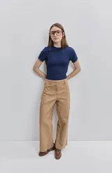 Pantalón verde militar de tiro medio y calce wide leg, con bolsillos laterales y cierre frontal con botón.