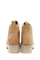 Borcego acordonado color beige de cuero liso con cordones y suela track.