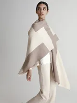 Poncho tipo spolverino bicolor, beige y visón, con diseño geométrico.
