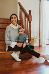 Polerón celeste con cuello alto blanco, de punto navarra. Tiene corte oversize y cierres laterales invisibles para amamantar.