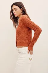 Cardigan cropped de punto calado color tostado, con escote en V, manga larga y cierre frontal con botones.