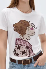 Remera de algodón de manga corta, color blanco, con cuello redondo y estampado frontal ilustrado con una mujer de perfil.