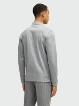 Polo azul de manga larga con cuello clásico y tapeta de dos botones. Presenta un pequeño logo bordado en el pecho. Corte recto.