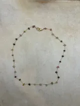 Collar de cadena dorada con pequeñas piedras de colores.