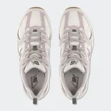 Championes New Balance modelo 530, de estilo retro, en color gris claro con detalles blancos y suela marrón. Combinan malla transpirable y refuerzos sintéticos con tecnología de amortiguación ABZORB.