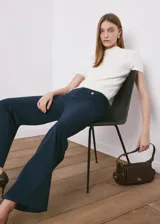 Pantalón azul marino de tiro medio, con bolsillos frontales decorados con botones metálicos dorados y diseño de perneras amplias y rectas.