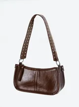 Bolso bandolera marrón de cuero sintético con tachas plateadas en el asa.