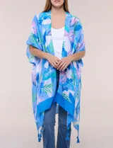 Kimono de gasa azul con estampado botánico de hojas tropicales en tonos celestes, verdes y rosados. Presenta un diseño abierto al frente con mangas cortas y amplias, ruedo asimétrico estilo pañuelo y detalle de borlas en las esquinas inferiores.