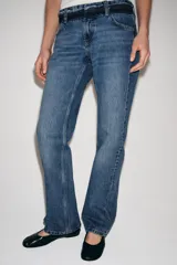 Jeans de tiro bajo y corte recto, confeccionados en denim con efecto lavado. Presentan cintura con trabillas, bolsillos delanteros y traseros, y cierre frontal con cremallera y botón.