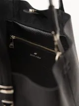 Cartera tipo tote Jazmín Chebar de cuero vacuno negro, con manijas superiores, correa regulable extraíble, acceso mediante imán y punteras metálicas decorativas.