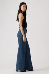 Jean de corte wide leg con costuras verticales frontales, tiro medio y cierre de botón y cremallera. Presenta un diseño de cinco bolsillos y trabillas para cinturón.