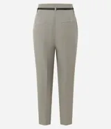 Pantalón de sastrería corte carrot, color beige, con cintura alta, pinzas frontales y cinturón fino incorporado con hebilla metálica.