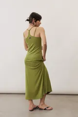 Vestido largo color verde suave, sin mangas, con escote redondo y silueta al cuerpo que se ensancha levemente hacia el dobladillo.