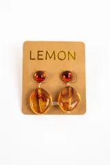 Aros colgantes con diseño de piedras en tonos ámbar y carey, compuestos por un botón superior semiesférico y un dije inferior de forma irregular.