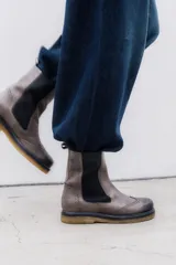 Bota tipo Chelsea de cuero vacuno color suela, con diseño brogue en la puntera y laterales. Presenta paneles elásticos laterales en color marrón oscuro, tirador trasero y suela de goma con plataforma.