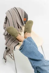 Zueco de gamuza color verde musgo, con diseño de punta redonda, ajuste mediante correa con hebilla metálica y suela de corcho anatómica.