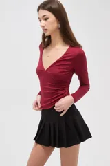 Remera de manga larga color bordó, con escote en V profundo y ajuste al cuerpo.