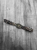 Cinto con estampado animal print de leopardo y hebilla metálica con forma de cráneo de toro.