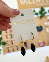 Aros colgantes dorados con dije ovalado de resina negra con vetas doradas.