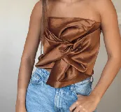 Top strapless color blanco, con diseño drapeado y nudo central.