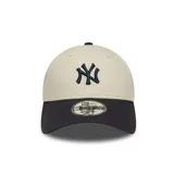 Gorra de béisbol New Era con visera curva, color beige con visera negra y logo de los New York Yankees bordado en azul marino.
