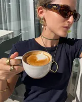 Aros colgantes de bronce dorado con diseño orgánico y perla de río natural en el extremo inferior.