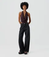 Pantalón wide leg de denim negro, con cintura media, bolsillos funcionales, presillas para cinturón y cierre frontal con botón y cremallera.