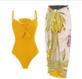 Traje de baño entero color mostaza con breteles finos y detalle de nudo en el centro del busto.