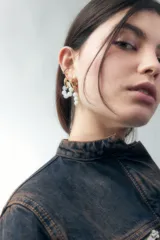 Aros dorados con forma de argolla, con cuentas blancas irregulares.