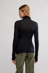 Remera de punto fino semitransparente, color negro, de calce ajustado, con cuello alto, mangas largas y orificios para los pulgares en los puños.