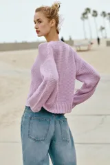 Chaqueta de punto grueso color lila con cuello redondo, manga larga, acabados en rib y cierre frontal con botones nacarados.